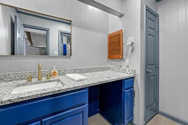 a bathroom with a granite countertop sink and a mirror