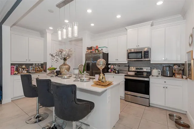 a kitchen with kitchen island granite countertop a sink cabinets and stainless steel appliances