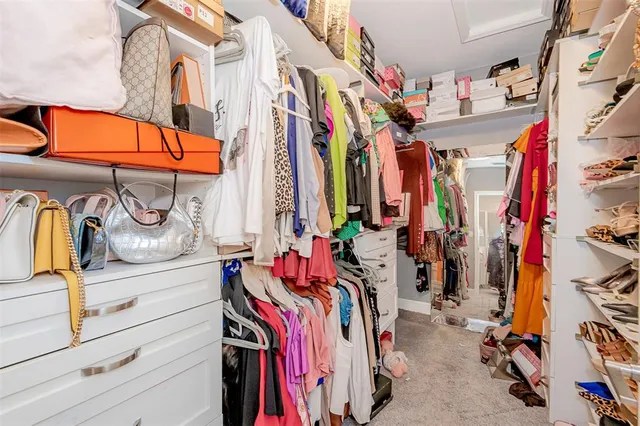 a view of walk in closet with clothes