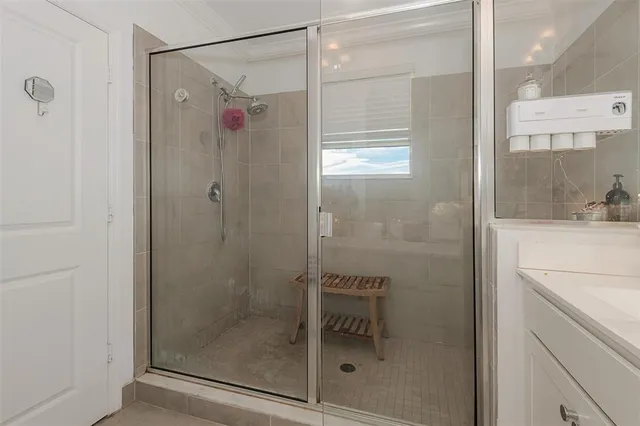 a bathroom with a shower and a sink a mirror