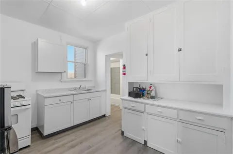 a kitchen with white cabinets and sink