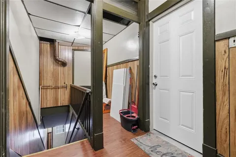a view of a hallway with wooden floor and stairs