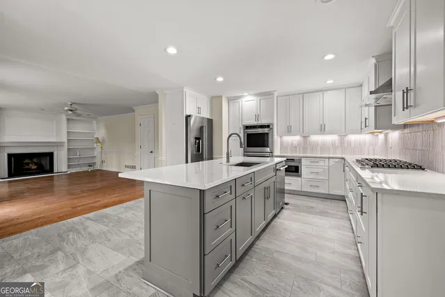 a large kitchen with stainless steel appliances kitchen island granite countertop a stove and a sink