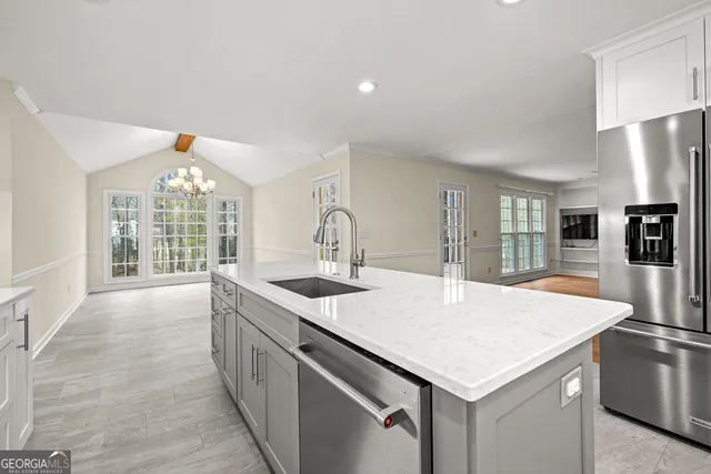 a kitchen with granite countertop a sink and refrigerator