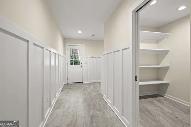 a view of a hallway with wooden floor and entryway