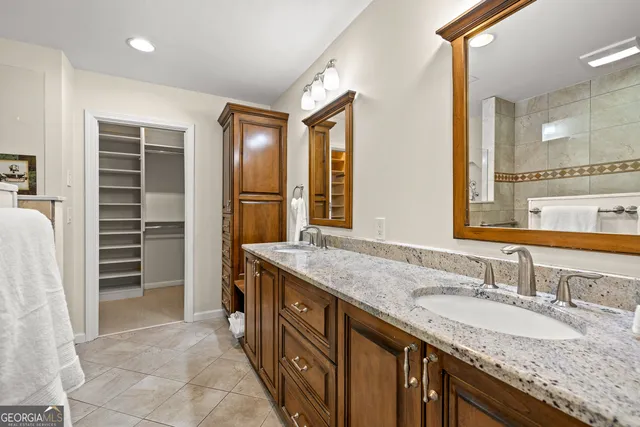 a bathroom with a granite countertop shower a mirror and a sink
