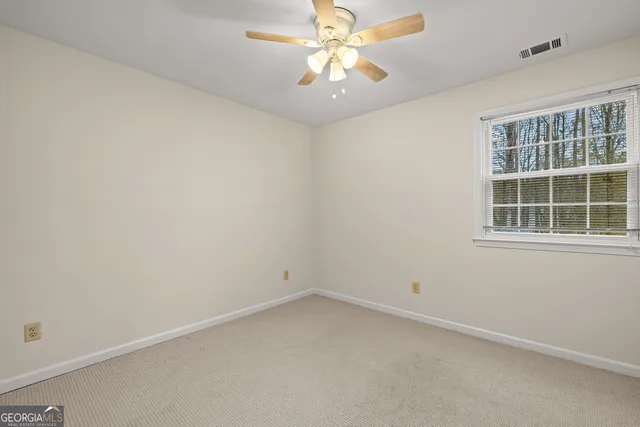 an empty room with a chandelier fan