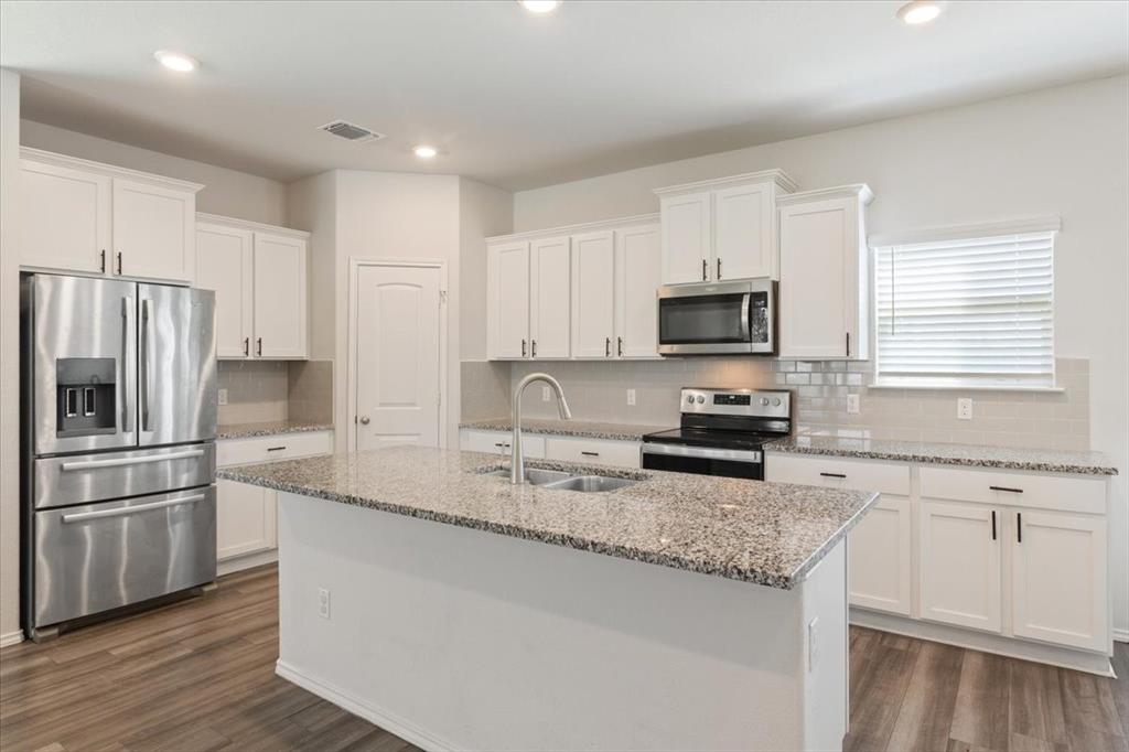 6317 Elephant Butte Drive Waco, TX 76708 - Photo 10 of 39 Kitchen island with stone-finish countertop and undermount sink