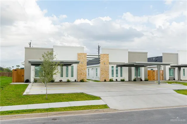 a front view of multiple houses with yard