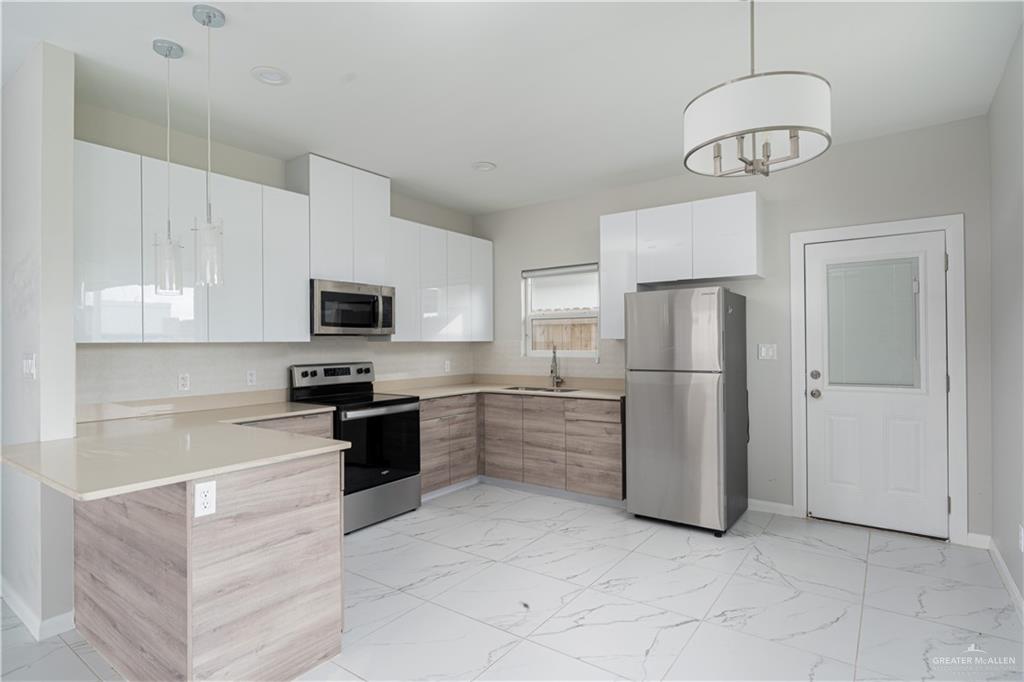 221 Rafael Drive, Unit 1 San Juan, TX 78589 - Photo 2 of 18 a kitchen with stainless steel appliances granite countertop a refrigerator a stove a sink and a microwave