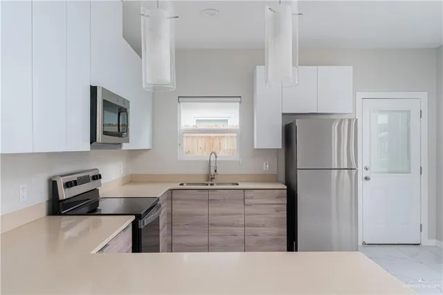 a kitchen with stainless steel appliances a refrigerator sink and stove