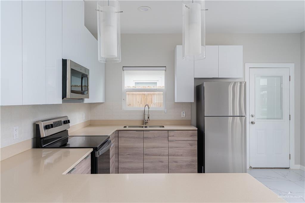 221 Rafael Drive, Unit 1 San Juan, TX 78589 - Photo 3 of 18 a kitchen with stainless steel appliances a refrigerator sink and stove
