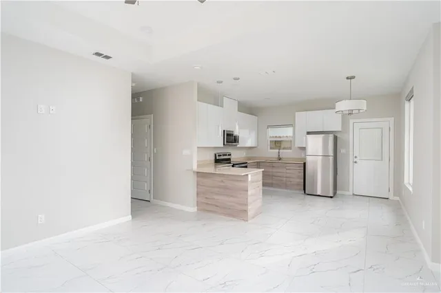 a kitchen with white cabinets and stainless steel appliances