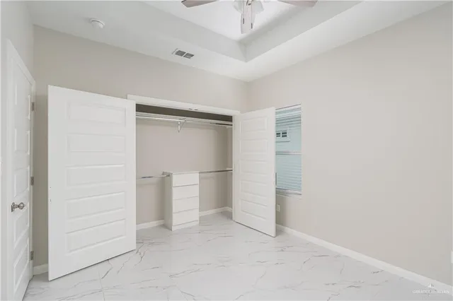 an empty room with closet and windows