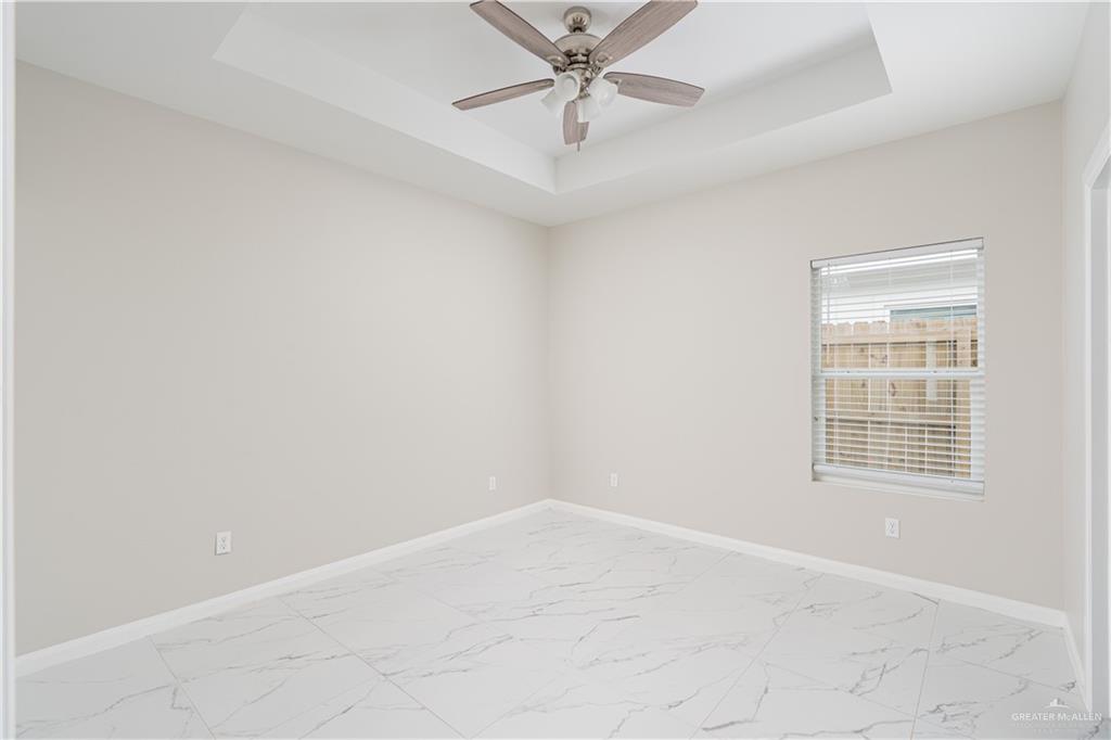 221 Rafael Drive, Unit 1 San Juan, TX 78589 - Photo 8 of 18 an empty room with a chandelier fan and windows