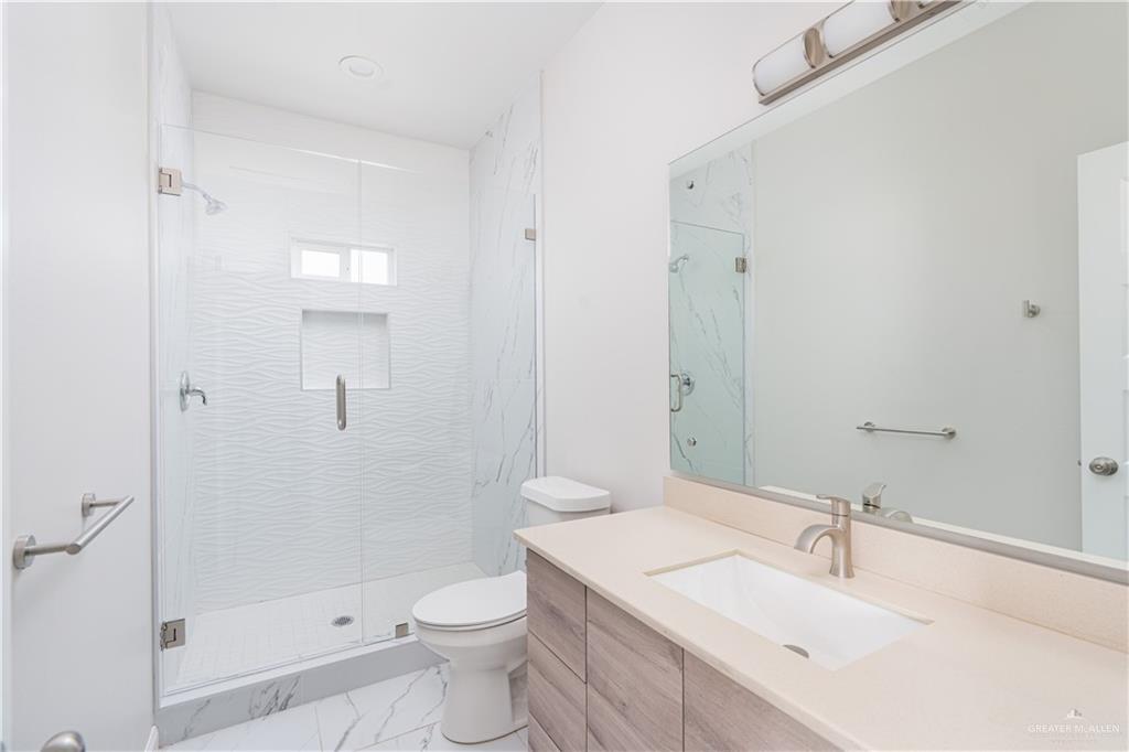 221 Rafael Drive, Unit 1 San Juan, TX 78589 - Photo 9 of 18 a bathroom with a sink toilet vanity and shower