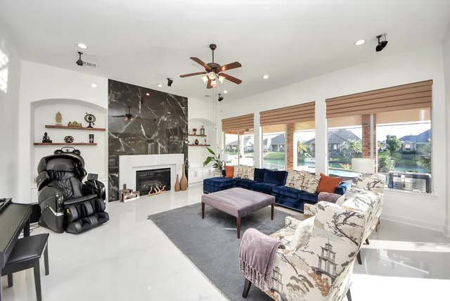 a living room with furniture a fireplace and a floor to ceiling window