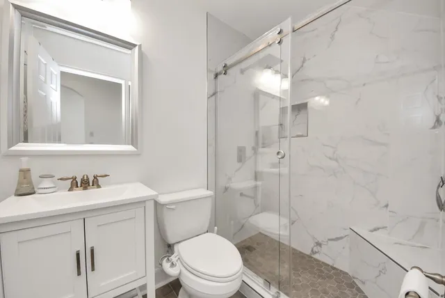 a bathroom with a sink toilet vanity and shower