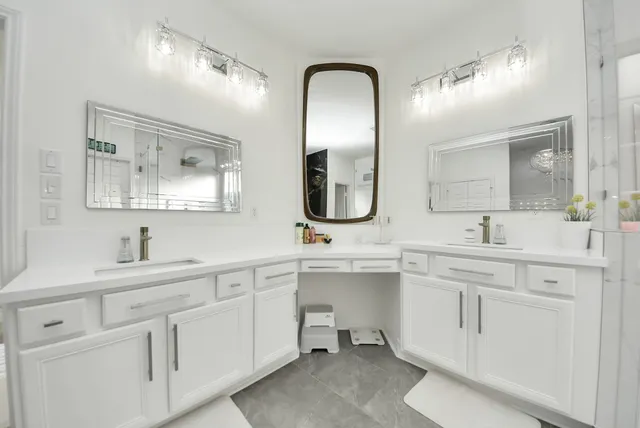a bathroom with double vanity sinks and a mirror
