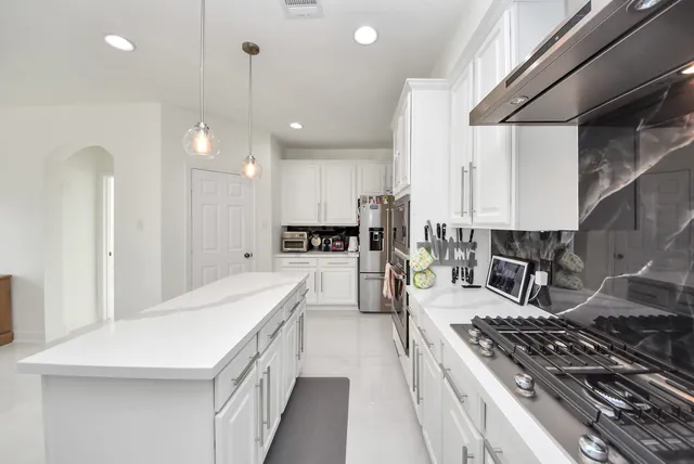 a kitchen with counter top space stove and refrigerator