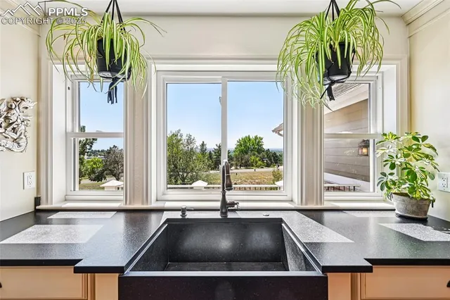 a kitchen with stainless steel appliances granite countertop a sink and a view of living room