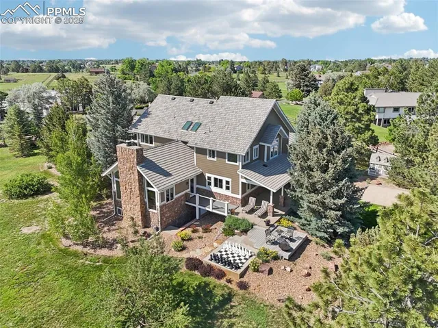 an aerial view of residential houses with outdoor space and trees
