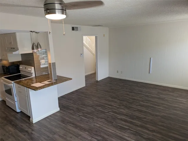 a kitchen with a stove and wooden floor