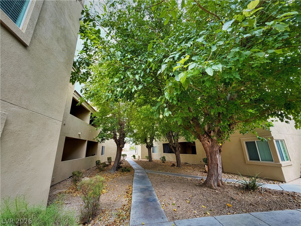 1852 North Decatur Boulevard, Unit 101 Las Vegas, NV 89108 - Photo 15 of 45 Mature trees shade a paved pedestrian pathway winding through the residential courtyard.