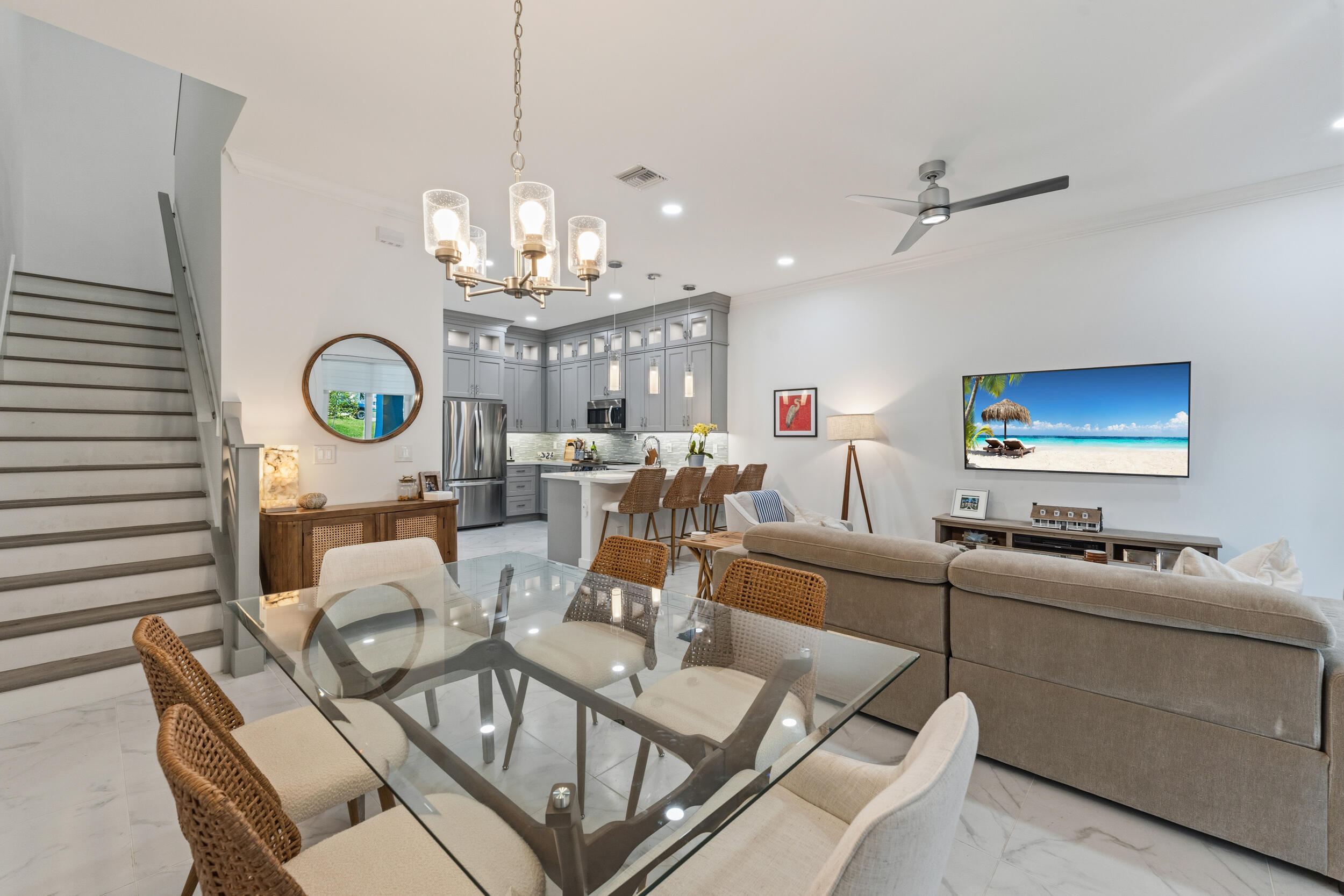 4692 Southeast Manatee Terrace Stuart, FL 34997 - Photo 14 of 47 a living room with furniture a chandelier and a flat screen tv
