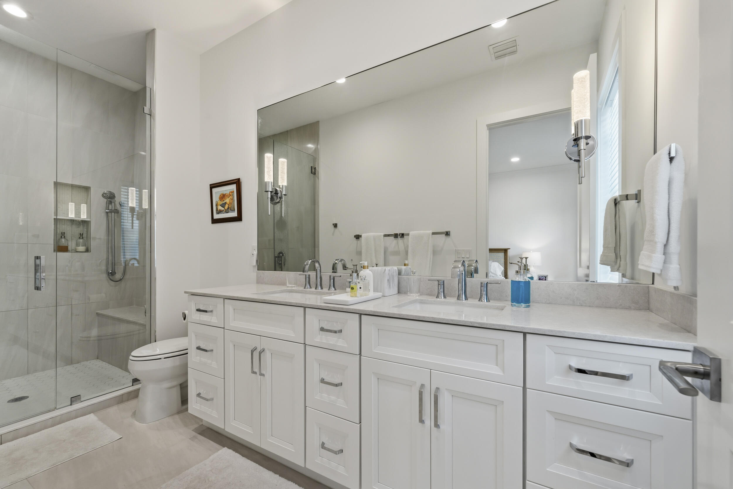 4692 Southeast Manatee Terrace Stuart, FL 34997 - Photo 20 of 47 a spacious bathroom with double sink a toilet a shower and a mirror