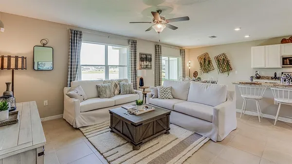 a living room with furniture ceiling fan and a window