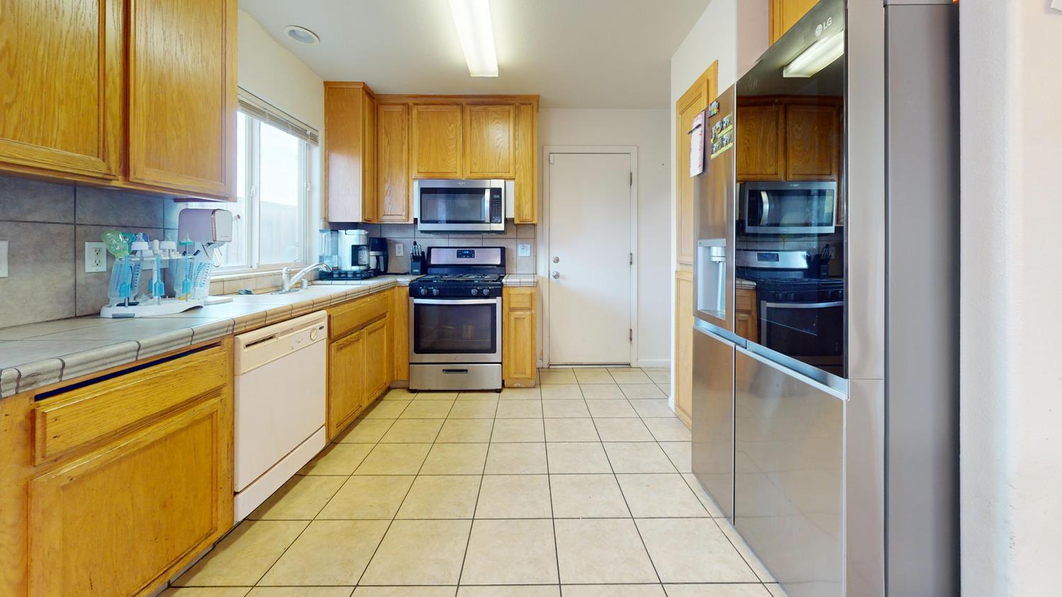 185 River Pointe Madera, CA 93637 - Photo 12 of 36 a kitchen with stainless steel appliances granite countertop a refrigerator and a sink