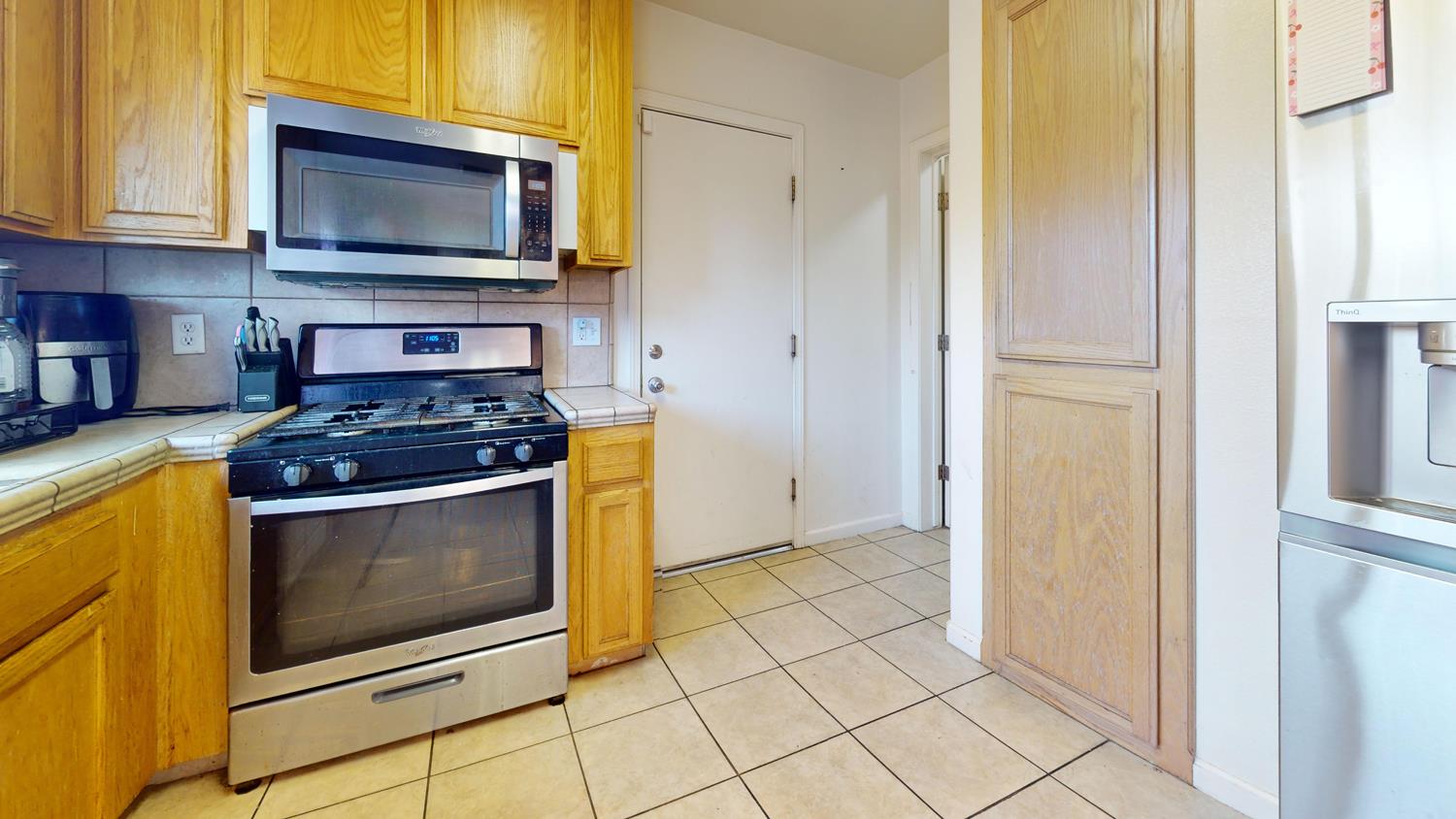 185 River Pointe Madera, CA 93637 - Photo 13 of 36 a kitchen with granite countertop a stove a microwave and a refrigerator