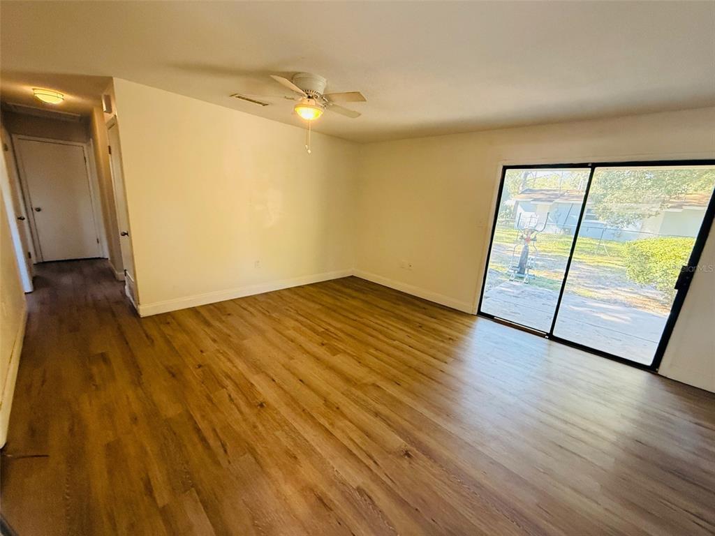 3818 Northeast 13th Drive Gainesville, FL 32609 - Photo 4 of 12 an empty room with wooden floor and door