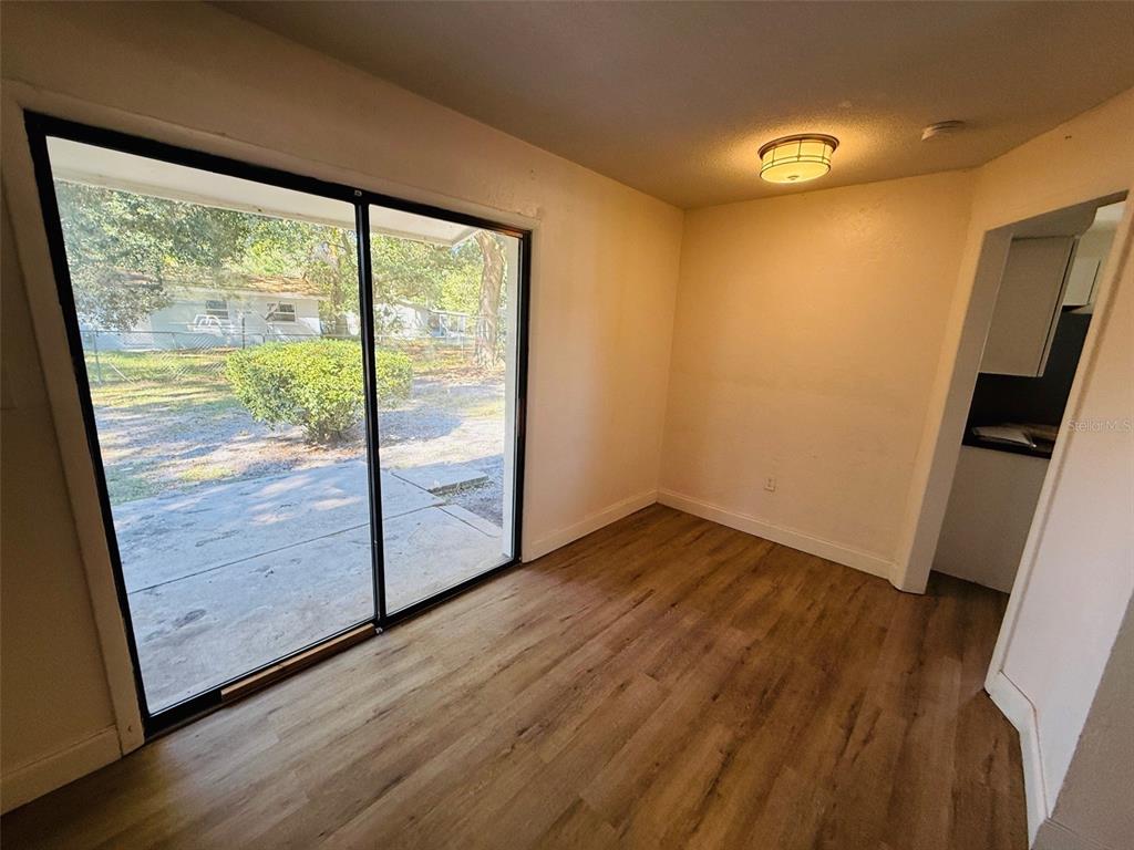 3818 Northeast 13th Drive Gainesville, FL 32609 - Photo 5 of 12 a view of an empty room with wooden floor and a window
