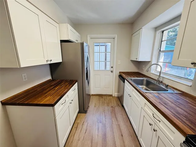 a kitchen with granite countertop a sink a counter space cabinets and stainless steel appliances