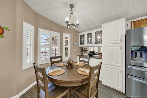a dining room with furniture a chandelier and wooden floor