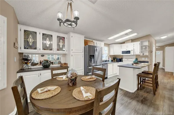 a kitchen with stainless steel appliances kitchen island granite countertop a dining table and chairs