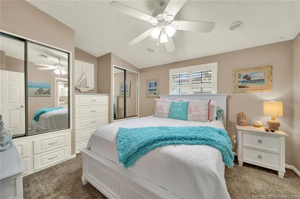 a spacious bedroom with a bed and a chandelier
