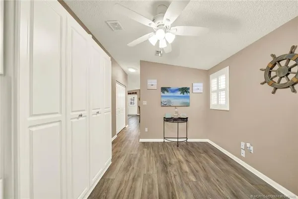 a view of a hallway with wooden floor and a chandelier