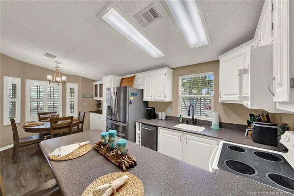 a kitchen with a table chairs refrigerator and stove