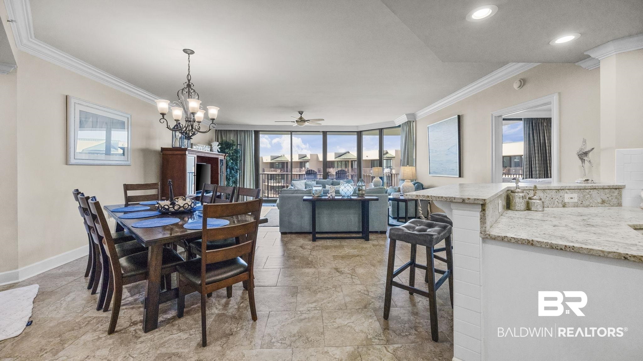 27580 Canal Road, Unit 1526 Orange Beach, AL 36561 - Photo 11 of 49 Dining space featuring ornamental molding, ceiling fan, a chandelier, and a wall of windows