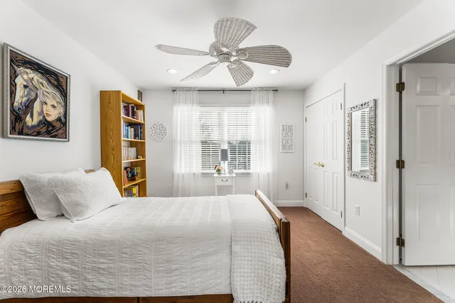 a bedroom with a bed and a ceiling fan