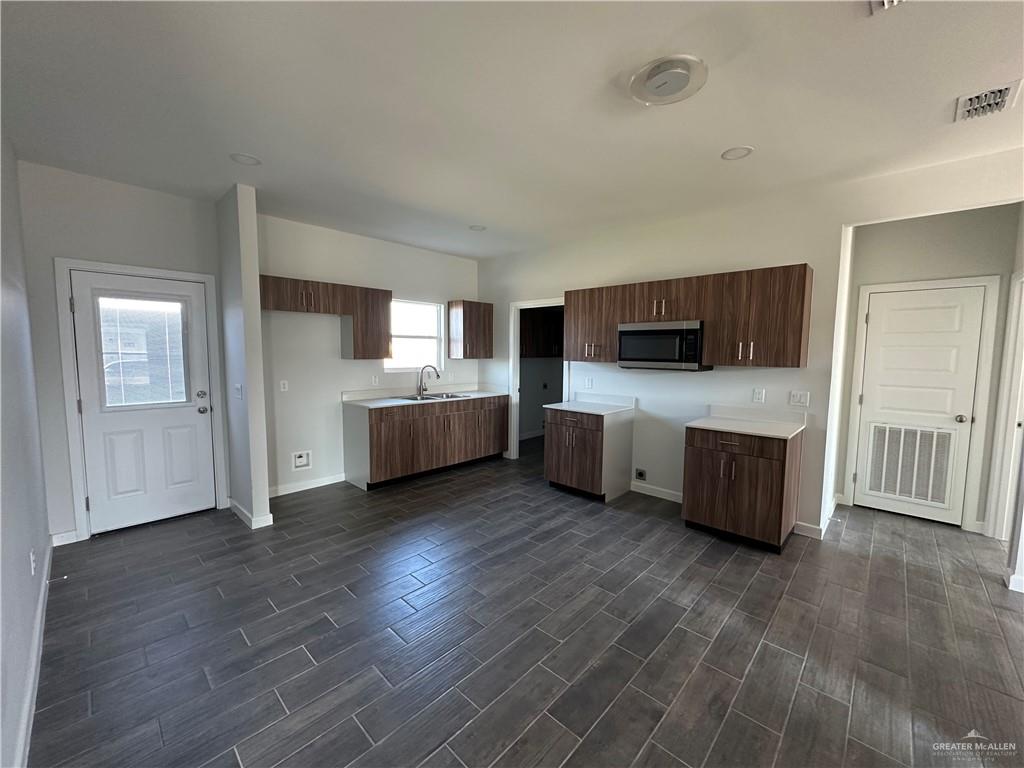 1605 Unity Drive Mercedes, TX 78570 - Photo 3 of 10 a large white kitchen with stainless steel appliances wooden floors and large window