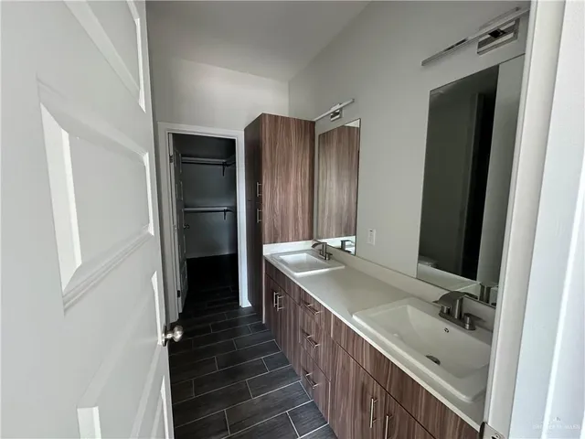a bathroom with a double vanity sink and mirror