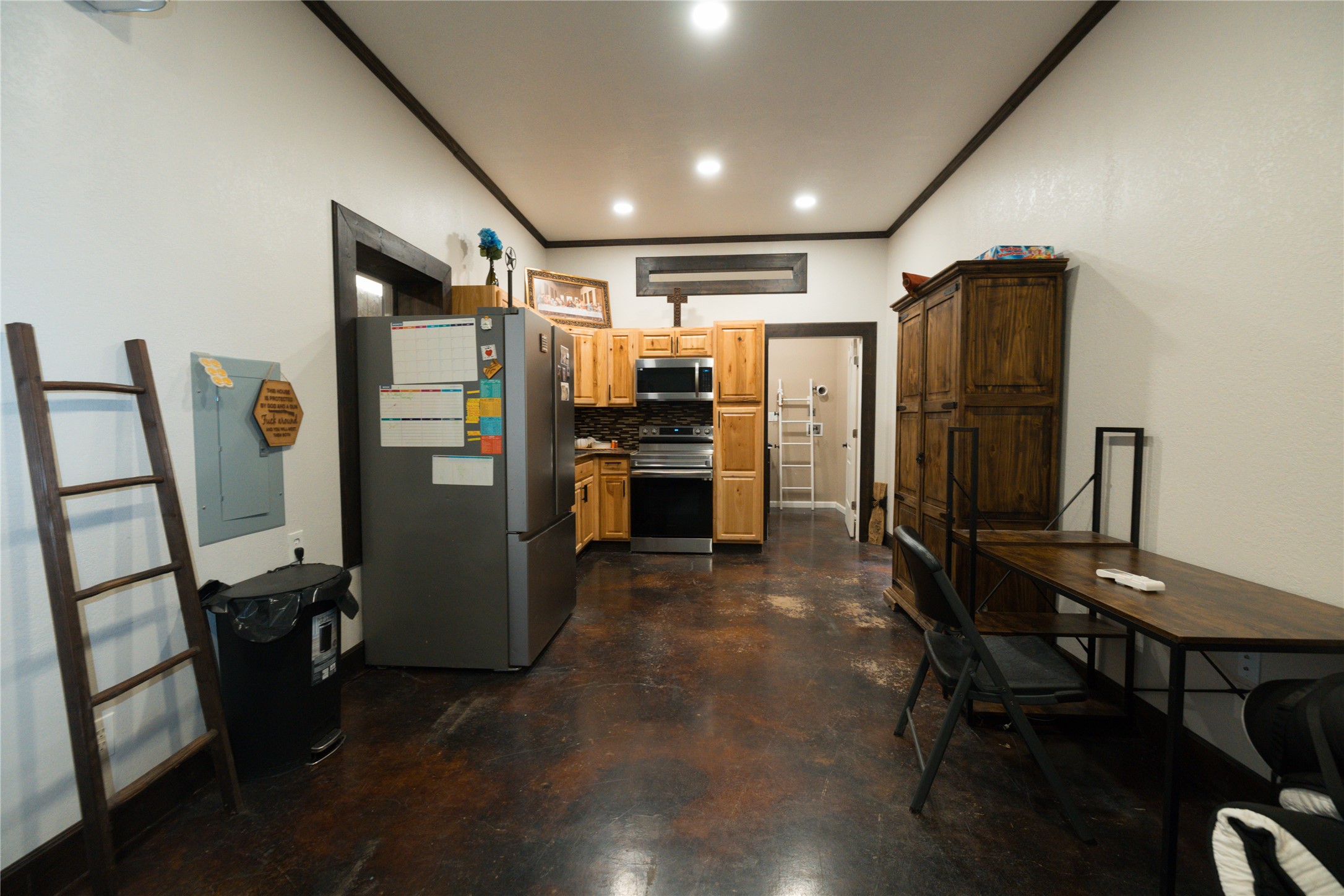 143 County Road Paige, TX 78659 - Photo 33 of 36 Guest house Kitchen featuring appliances with stainless steel finishes, concrete flooring, custom wood molding, trim, and base boards.