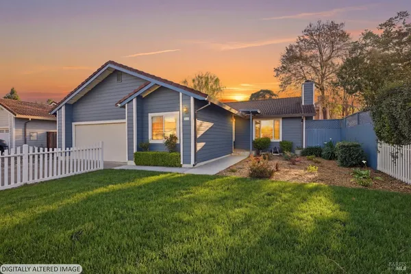 a view of a house with a yard and pathway