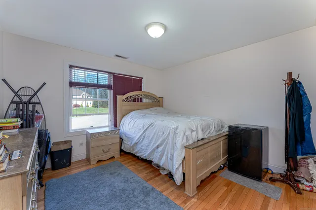 a bedroom with a bed and a flat tv screen on the dresser