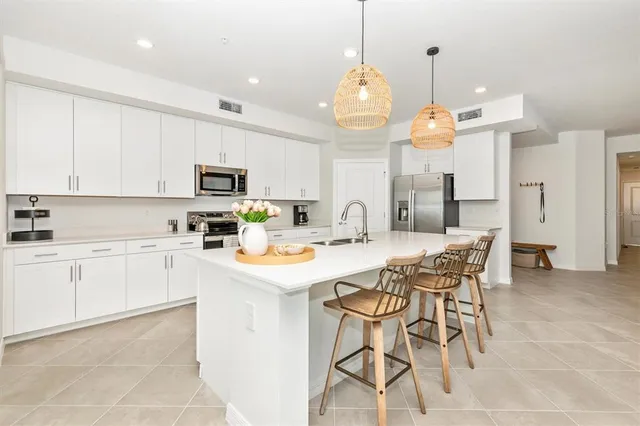 a view of a dining room and livingroom with furniture wooden floor a chandelier