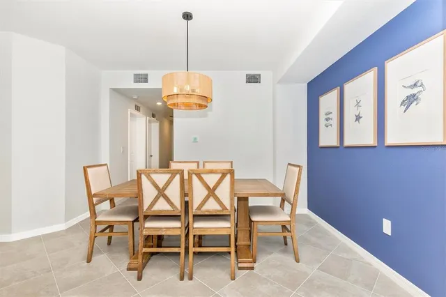 a living room with furniture kitchen view and a chandelier